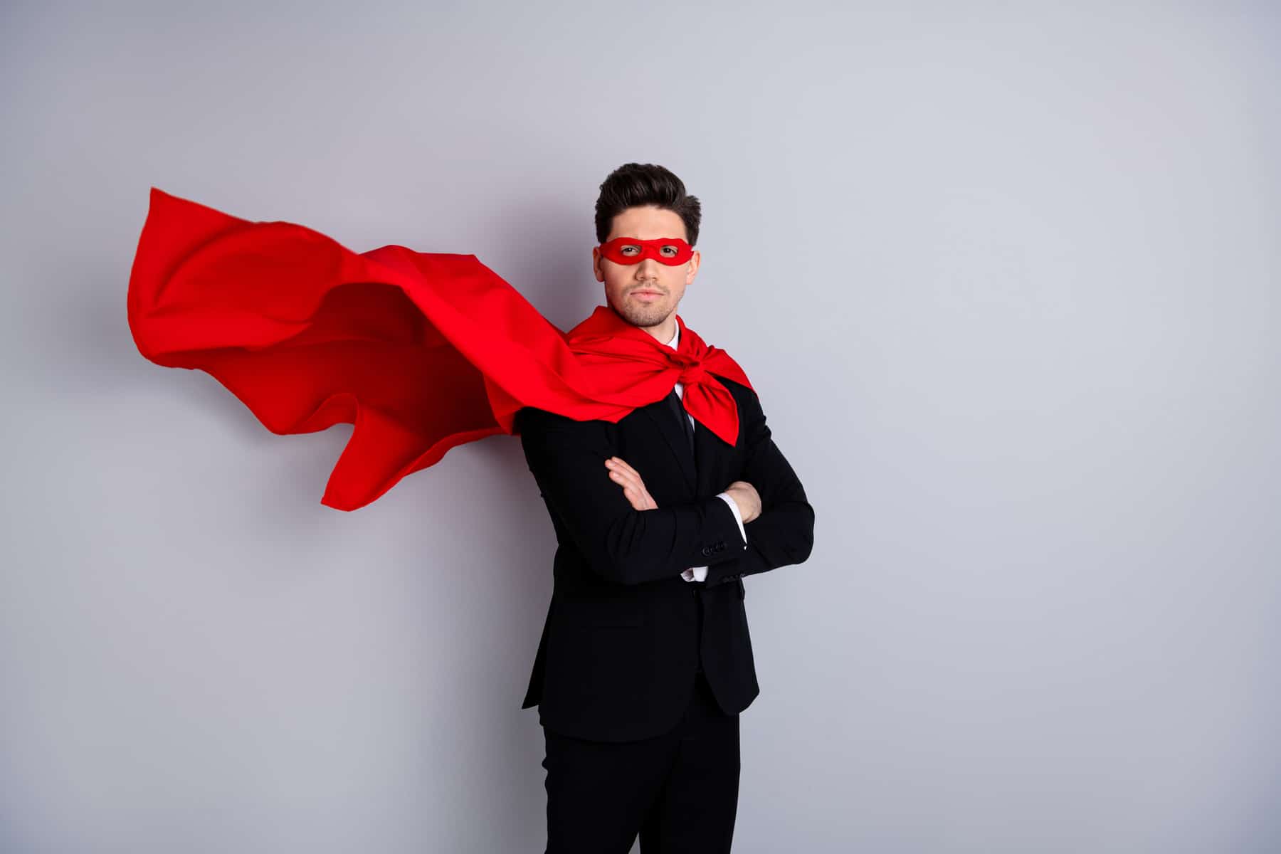 Führungskraft im Anzug und roten Cape, die durch Employer Branding Agentur wie Superheld erscheint