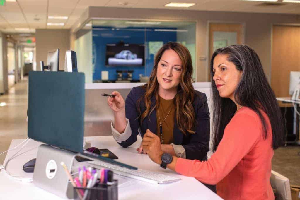 Zwei HR-Manager diskutieren vorm Laptop, was eigentlich Personalmarketing ist